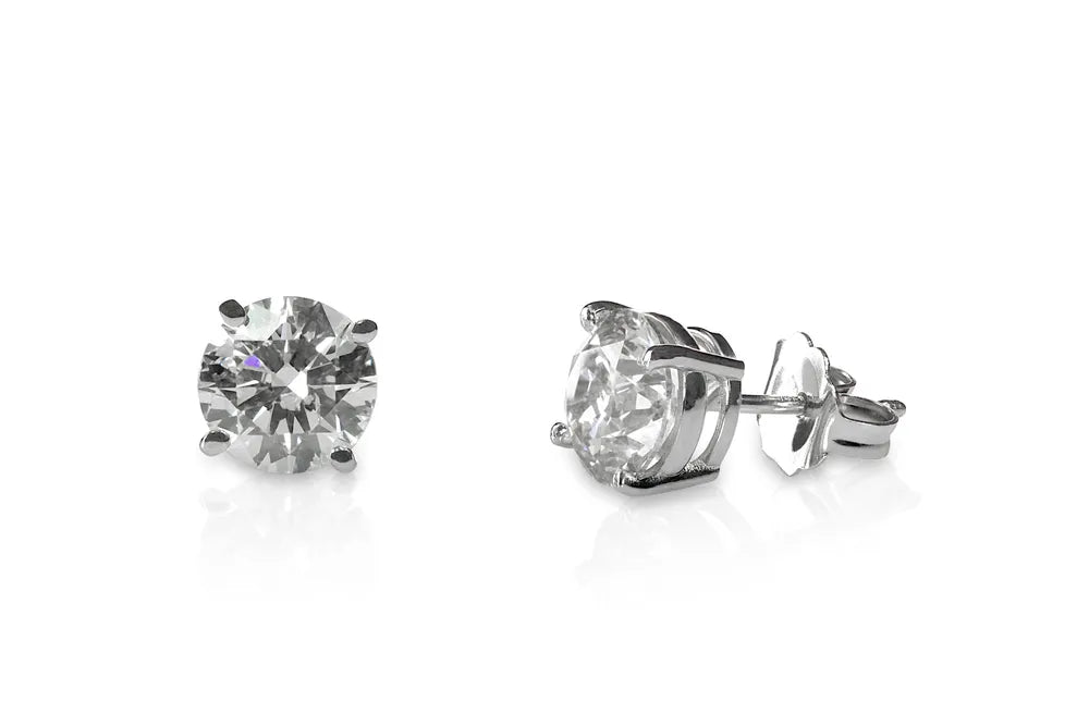A pair of round brilliant diamond stud earrings in white gold