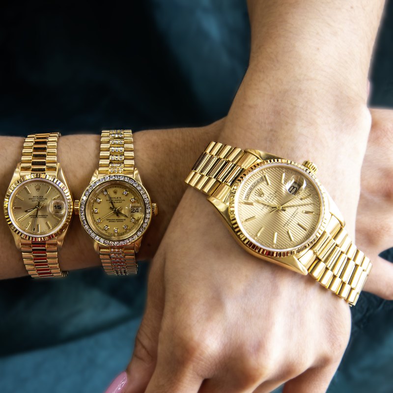 Three gold Rolex watches worn on two wrists