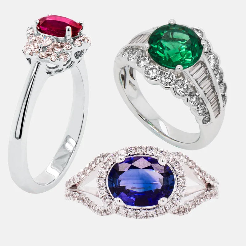 Three gemstone rings set with ruby, emerald and blue center stones and diamond accents