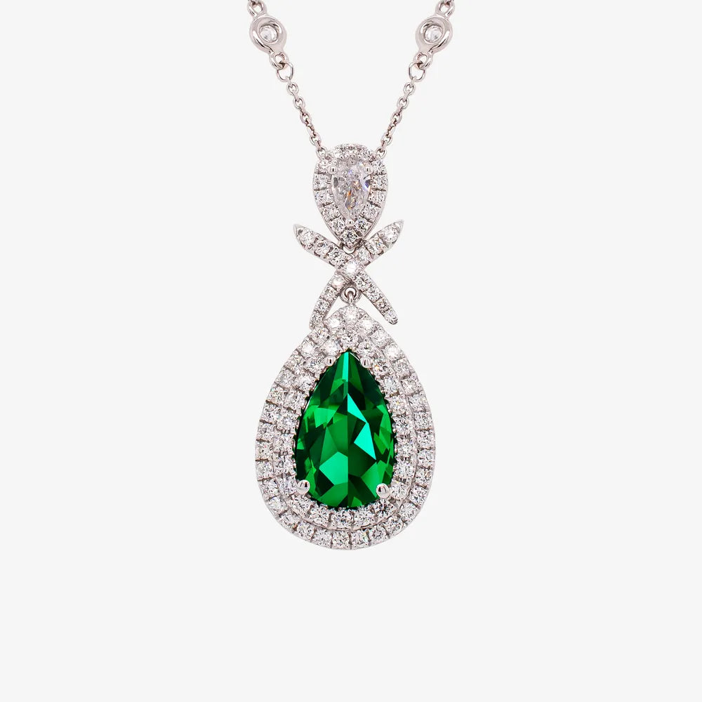 Pear shaped green gemstone pendant framed in a double halo of diamonds on a white gold chain