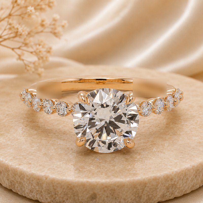 Round brilliant diamond solitaire engagement ring in yellow gold with a delicate diamond band