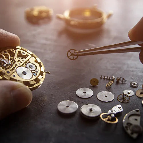 Watchmaker servicing the internal movement of a watch