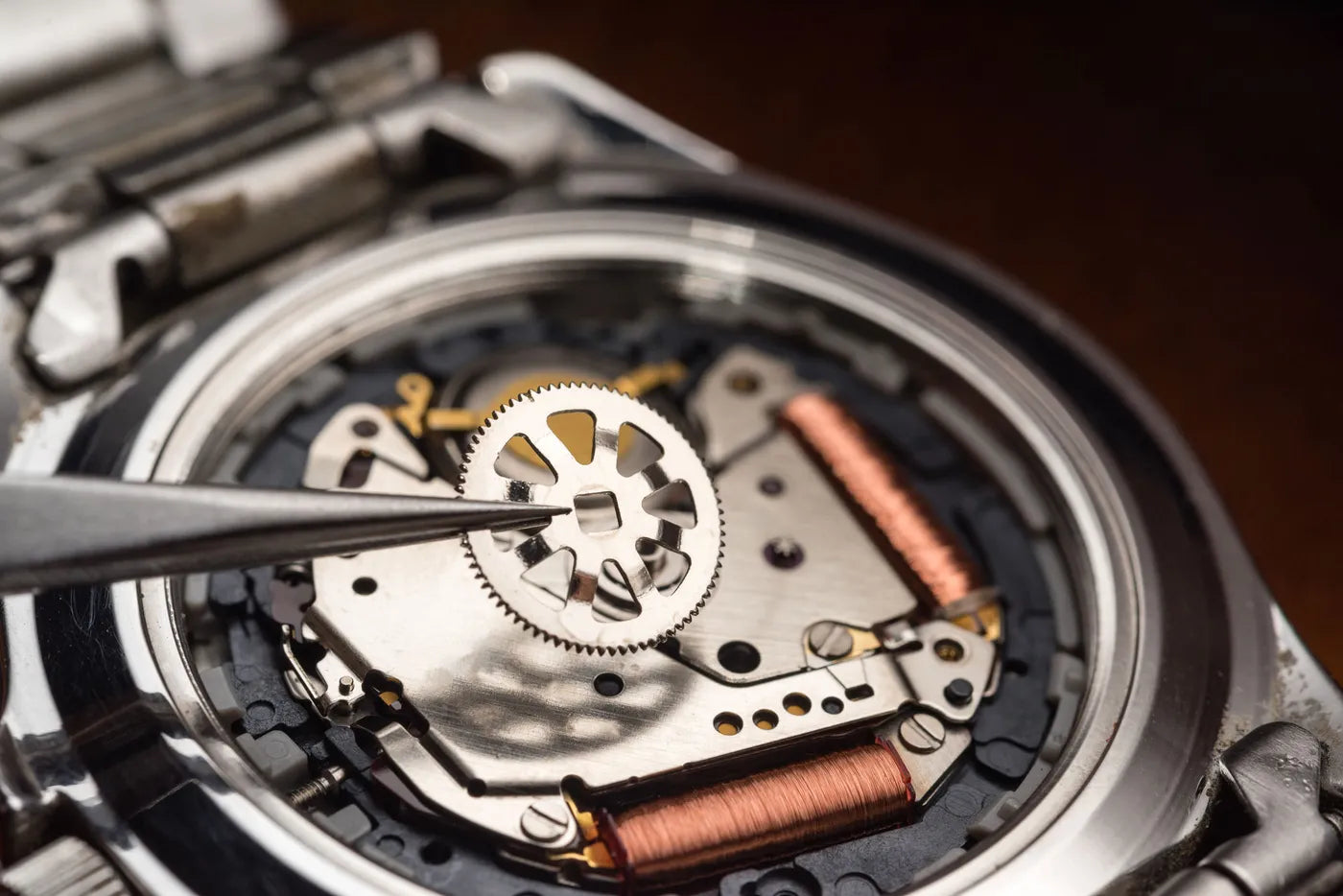 Close-up of a watchmaker's hands reassembling a watch movement